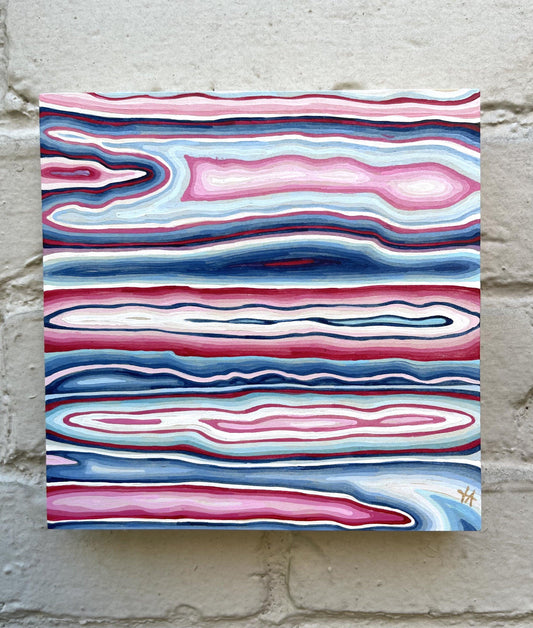 abstract square painting in pink and blue tones on grey brick wall