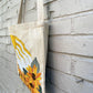 side view of canvas tote bag with painting of sunflowers and sun