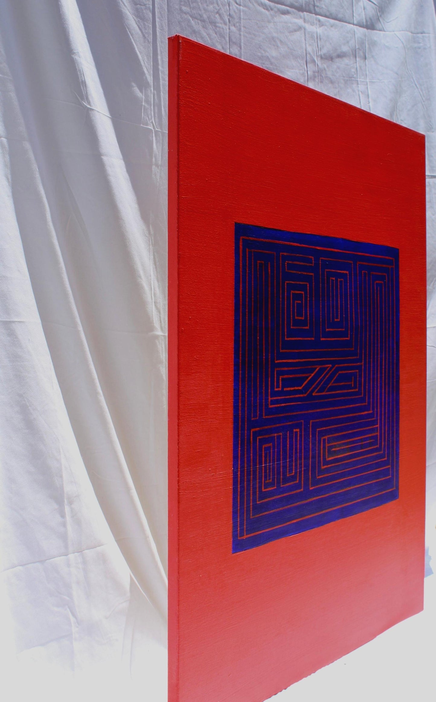 side view of red rectangle with centered blue square with red maze lines inside