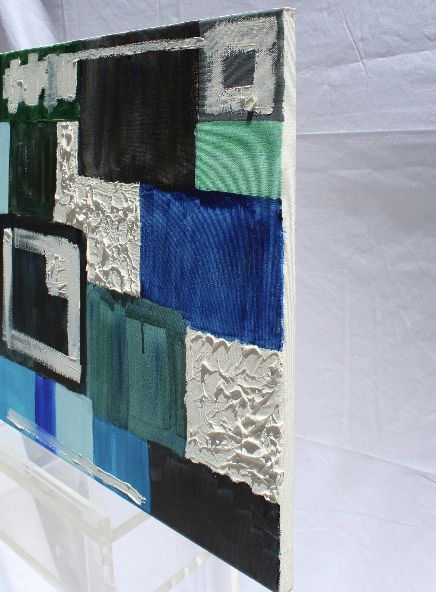 Side view of blue, green, and white abstract painting