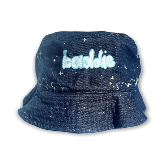 Denim bucket hat painted with word baddie in the center