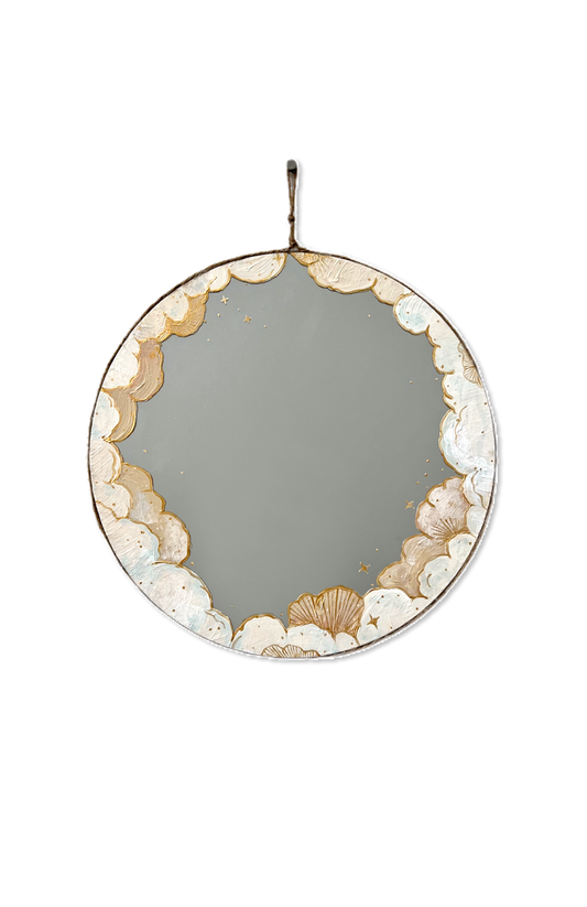 round mirror painted with white and cream clouds