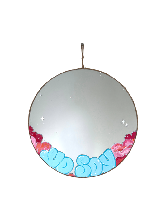 round mirror with light blue writing and pink clouds on bottom