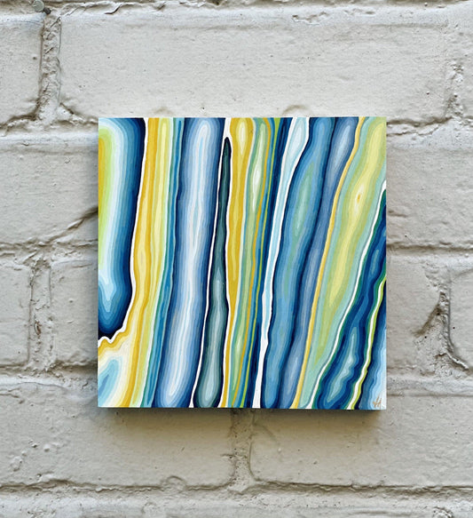 blue, green, yellow, and white abstract vertical wood pattern on grey brick wall