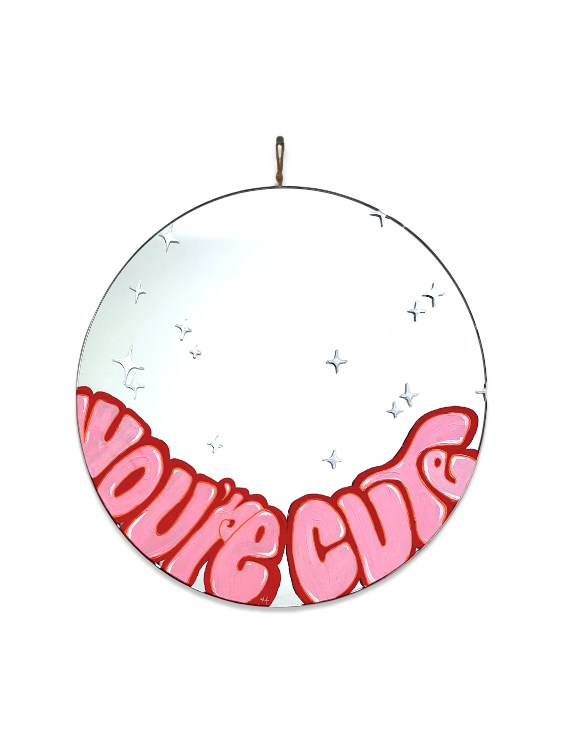 round mirror with light pink writing on the bottom and outlined in red. White sparkles on the mirror.