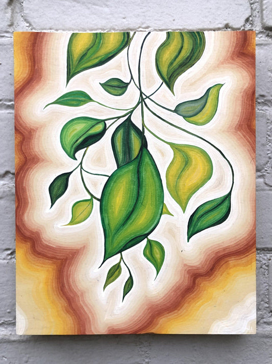 green leaves and vines painted in center of canvas with white, brown, and yellow outline on grey brick wall