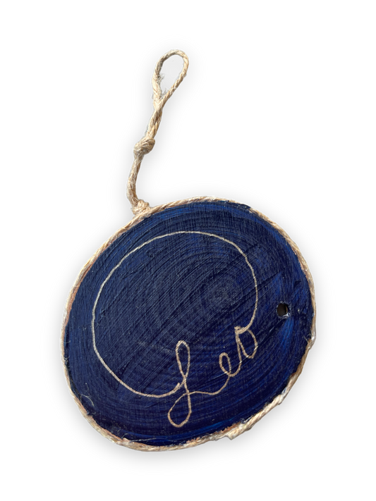 leo painted on three by three wooden ornament