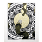 two black, white, and gold snakes meeting at center of page on top of circular gold pattern and black and white shapes 