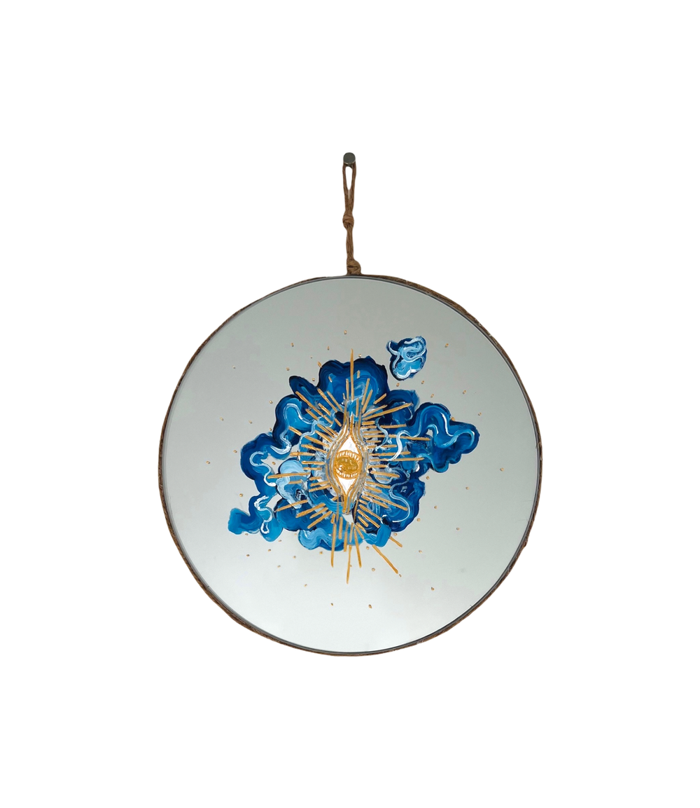 round mirror. abstract blue and white cloud in center with gold eye and rays on top